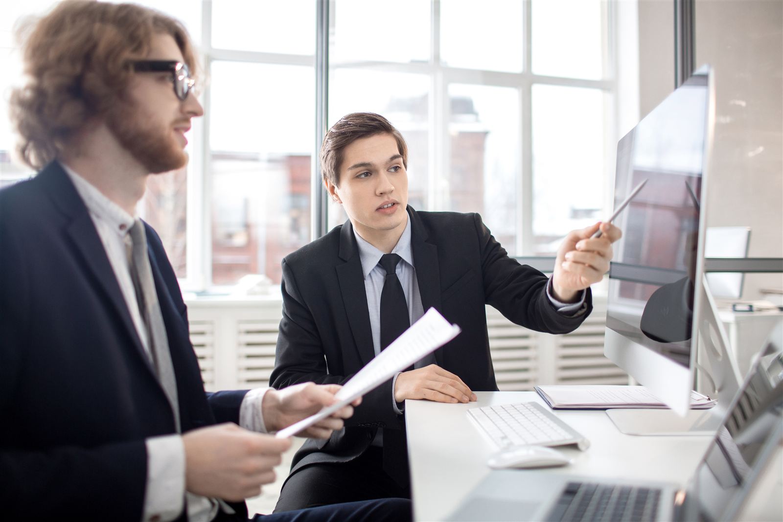 Two professionals discussing work in an office